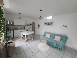a living room with a blue couch and a table at Maisonnette abj in Anneyron