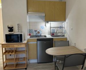 a small kitchen with a table and a microwave at Studio Pin Rolland, presqu’île Saint-Mandrier in Saint-Mandrier-sur-Mer