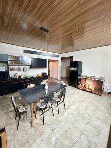 a living room with a table and chairs and a kitchen at Casa em Península de Maraú in Marau