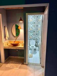 a bathroom with a sink and a toilet and a mirror at Casa em Península de Maraú in Marau