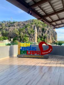 una señal para un hotel con una montaña en el fondo en Hotel Grutta, en Bom Jesus da Lapa