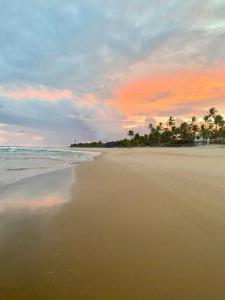 a beach with palm trees and the ocean at sunset at Casa em Península de Maraú in Marau +48 photos