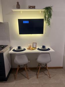 uma cozinha com duas cadeiras e uma mesa com dois pratos em Studio na Orla em Salvador