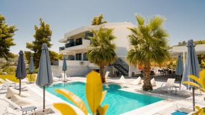 a resort with a swimming pool with chairs and umbrellas at Pine Resort in Polychrono