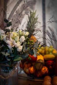 un vase rempli de fleurs à côté d'un bol de fruits dans l'établissement Givernel, à Giverny
