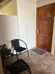 a room with a chair and a wooden door at Hotel y Restaurante Mama Ines in Santa Catalina