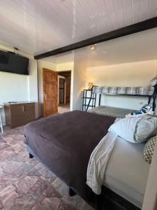 a bedroom with two bunk beds and a television at Hotel y Restaurante Mama Ines in Santa Catalina