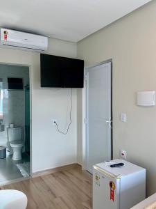 a white room with a refrigerator and a toilet at Hotel Grutta in Bom Jesus da Lapa