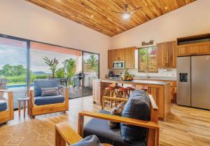 a living room with a couch and a kitchen at Villa Roca Ocean to Mountain Views - by Pura Villas in Ojochal