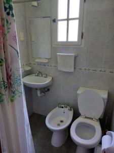 a bathroom with a white toilet and a sink at La Cabañita in Villa General Belgrano