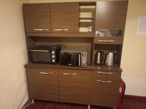 a microwave sitting on top of a wooden cabinet at Casa Cely in Iquique