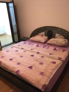 - un lit avec des coeurs violets dans une chambre dans l'établissement Apartman Marija, à Kupres