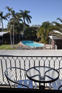 a table and chairs on a balcony with two pools at Longreach Motor Inn in Longreach