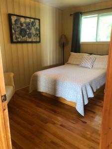 1 dormitorio con cama y ventana en Le chalet du Golf à Rimouski, en Rimouski