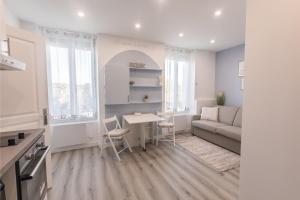 a living room with a table and a couch at Studio cosy / Parking / Wifi in Corbeil-Essonnes