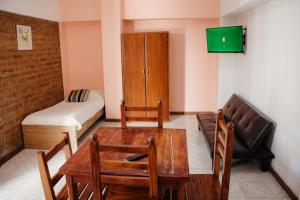 Habitación con mesa, sofá y cama en Hotel Pintó Terraza en Esquel