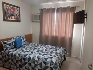 1 dormitorio con cama y ventana en Rio Quente-GO SERRA PARK com 2 camas de casal en Rio Quente