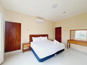una camera da letto con un grande letto bianco e una finestra di Casa Azul Cielo a Dzilam de Bravo