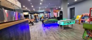 a room with arcade games and a ping pong table at Mobilhome 6 à 8 personnes camping 4 etoiles in Saint-Cyprien