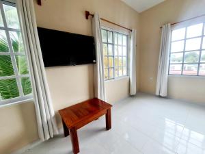 uma sala de estar com uma televisão de ecrã plano e um banco em Casa Azul Cielo em Dzilam de Bravo