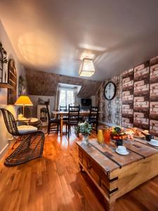 a living room with a table and a clock on the wall at Givernel in Giverny