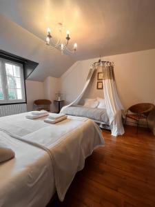 a bedroom with two beds and a chandelier at Givernel in Giverny
