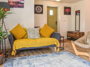 ein Wohnzimmer mit einem Sofa und einer gelben Decke in der Unterkunft Blundens Dawmill in Chichester