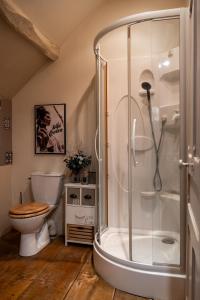 La salle de bains est pourvue d'une douche et de toilettes. dans l'établissement Givernel, à Giverny