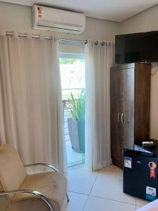 sala de estar con silla y puerta corredera de cristal en Hotel Grutta, en Bom Jesus da Lapa 33 fotos más