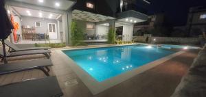una piscina en un patio trasero por la noche en Armonia Apartments, en Keramotí