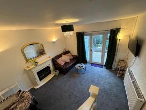 a living room with a couch and a mirror at Comfy 2 bedroom house, newly refurbished, self catering, free parking, walking distance to Cheltenham town centre in Cheltenham