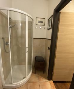 La salle de bains est pourvue d'une douche avec une porte en verre. dans l'établissement Dall’antiquario, à Parme