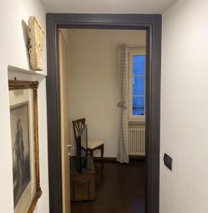 a hallway with a door leading to a room with a chair at Dall’antiquario in Parma