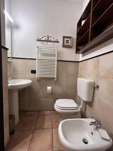 La salle de bains est pourvue de toilettes blanches et d'un lavabo. dans l'établissement Dall’antiquario, à Parme