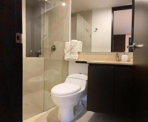 a bathroom with a toilet and a glass shower at Hotel en Rionegro-Rioverde- Apartamento in Rionegro