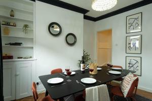 a dining room with a black table and chairs at NEW DEALS - Spacious, Stylish Home - Wi-Fi, Smart TV, Parking & Outdoor Area in Leicester