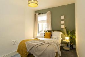 um quarto com uma cama e uma janela em NEW DEALS - Spacious, Stylish Home - Wi-Fi, Smart TV, Parking & Outdoor Area em Leicester
