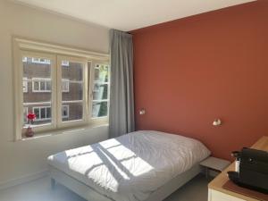 Schlafzimmer mit einem Bett und einem Fenster in der Unterkunft Terra City West in Amsterdam