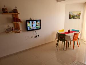 ein Esszimmer mit einem Tisch und einem TV an der Wand in der Unterkunft Résidence Sayadi - Chatt Meriam - Sousse in Port El-Kantaoui
