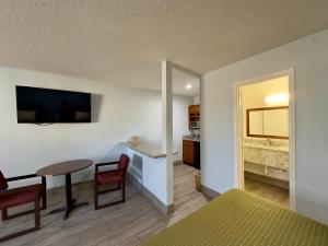 sala de estar con mesa y dormitorio en Razorback Inn, en Rogers