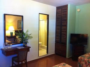 a room with a desk and a mirror and a bathroom at Hotel Iberia - San Juan in San Juan