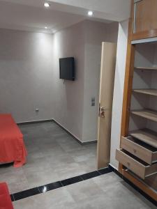 um quarto com uma cama e uma televisão na parede em Bel appartement de 54 M² bien meublé situé au coeur de Marrakech et à proximité de toute commodité em Marrakech