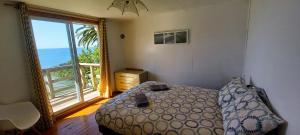Un dormitorio con una cama y una ventana grande en Cabaña Coliumo Tomé, en Dichato 19 fotos más