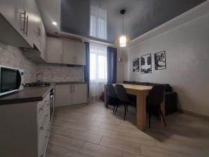 - une cuisine et une salle à manger avec une table et des chaises dans l'établissement Апартаменти в новобудові, à Kulʼparkuv
