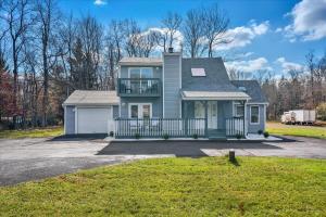a blue house with a balcony on a driveway at Heart of Pocono Mtn 3bd 2ba Gameroom Pocono Raceway in Long Pond