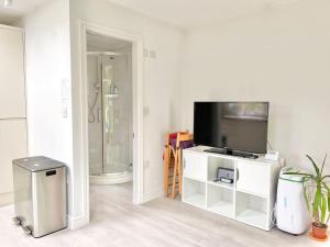 a living room with a tv and a bathroom at Entire Flat Free Parking Quiet Area *Self-Check In in Headingley