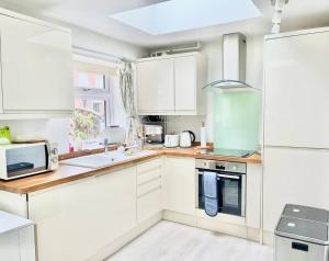 a kitchen with white cabinets and a stove top oven at Entire Flat Free Parking Quiet Area *Self-Check In in Headingley