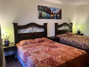 1 dormitorio con 2 camas y una foto en la pared en Casa Harding, en Guatemala