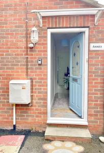 a brick house with a blue door and aperature at Entire Flat Free Parking Quiet Area *Self-Check In in Headingley