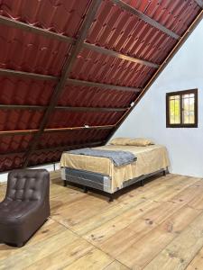 a attic room with a bed and a chair at CABAÑA RIO ATULAPA #1 in Esquipulas
